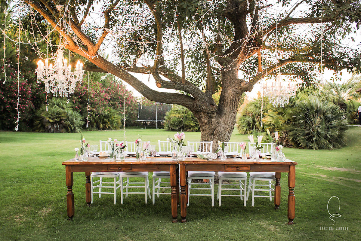 Mesa preparada en un jardín para una comida familiar de celebración